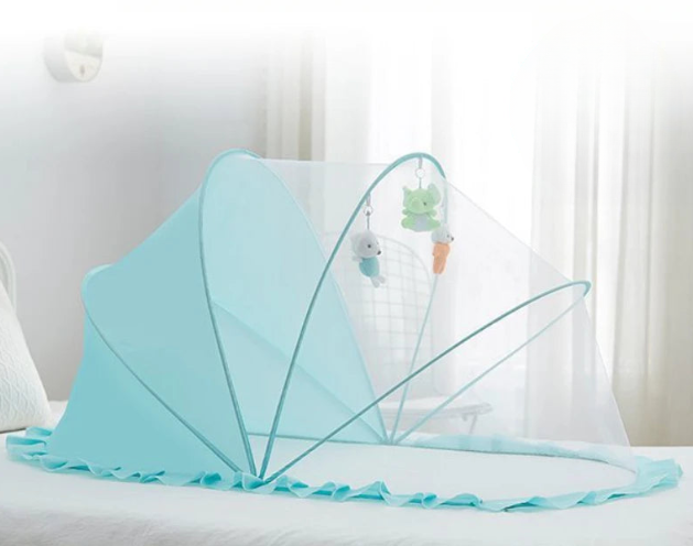 Turquoise baby crib canopy on a bed with white curtains in the background